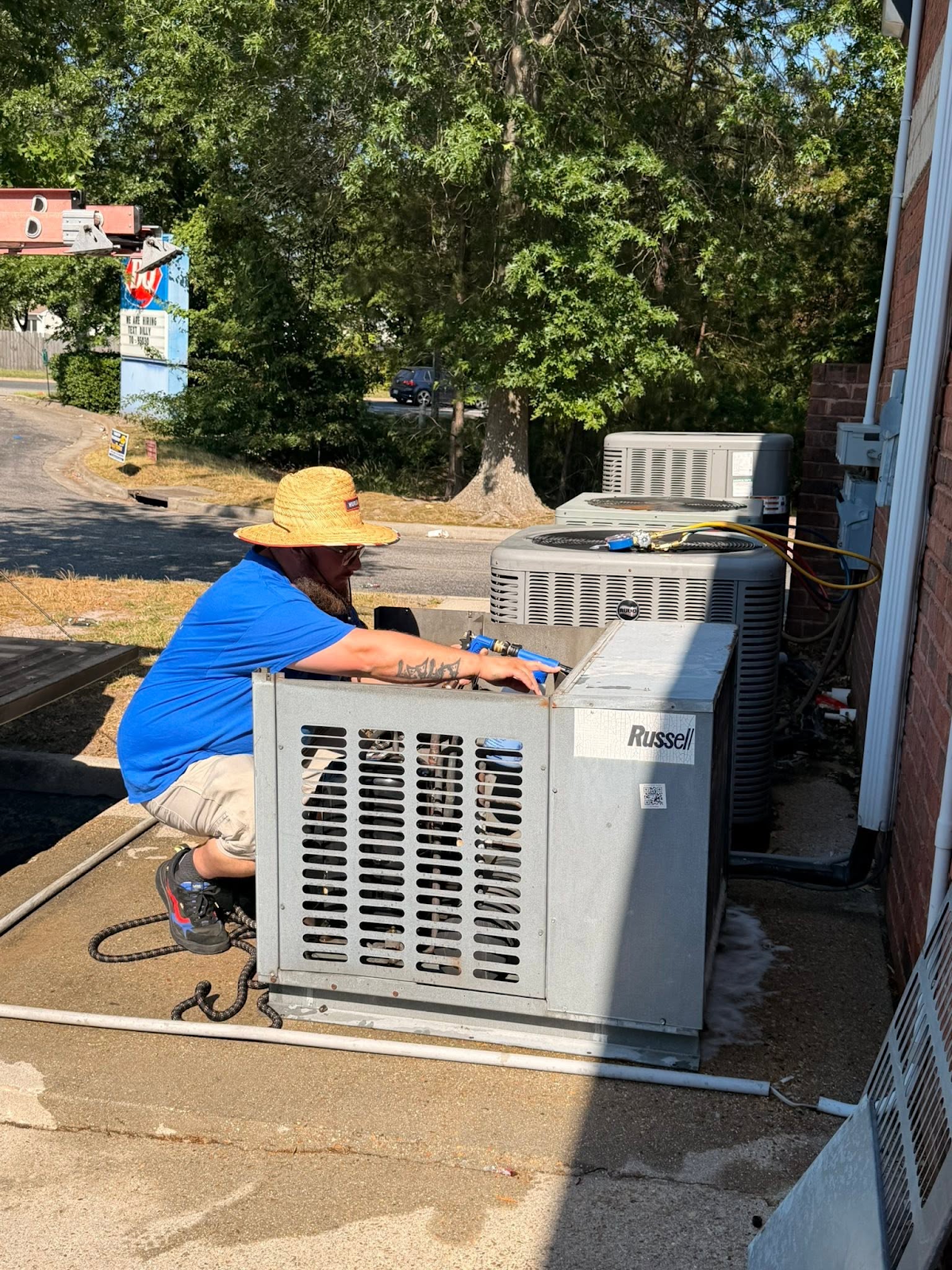 Ferguson & Sons technician performing maintenance on outdoor HVAC equipment
