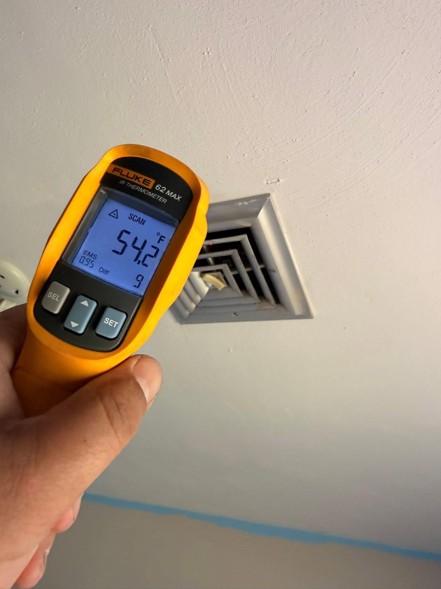 Technician measuring supply-air temperature during furnace service