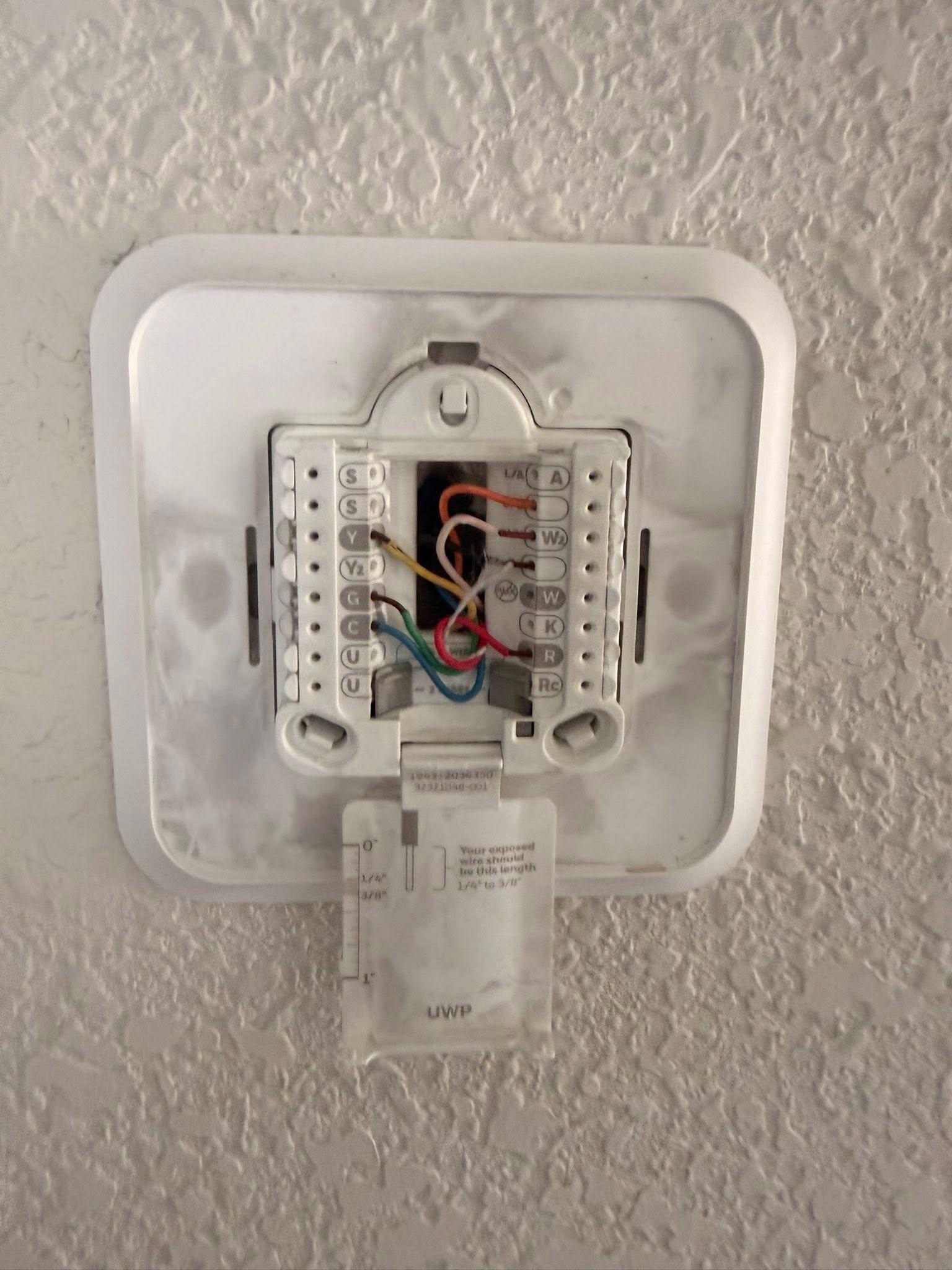 Thermostat wiring and wall plate exposed during replacement service