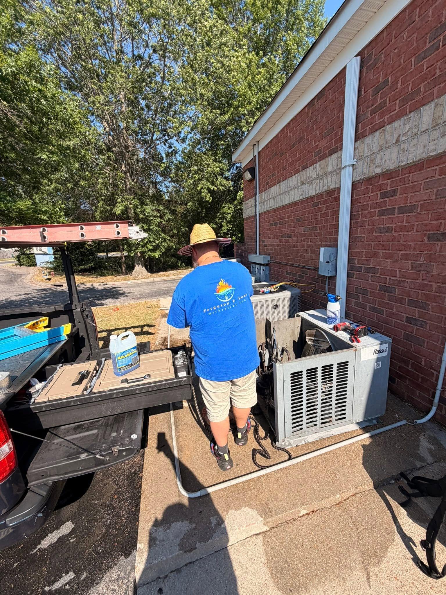 Technician servicing residential outdoor HVAC equipment